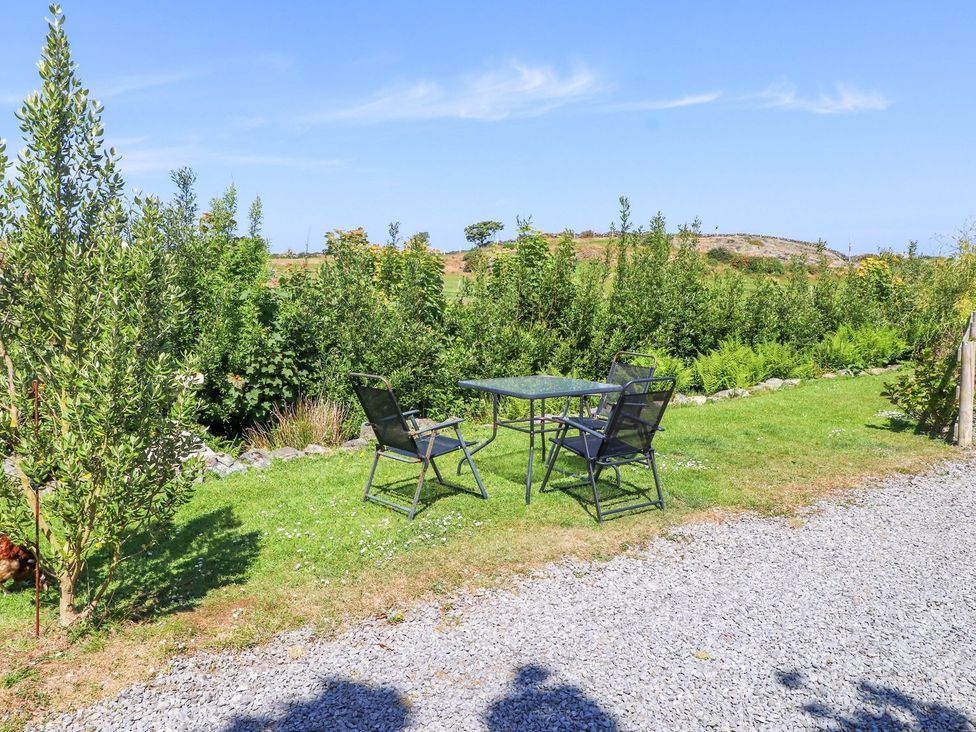 A table and chairs in a garden at The Lodge in Amlwch