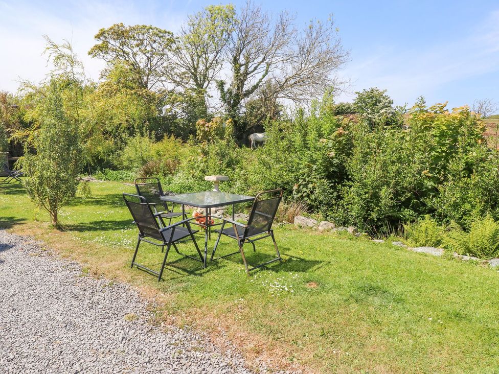 A garden with a table and chairs at The Lodge in Amlwch