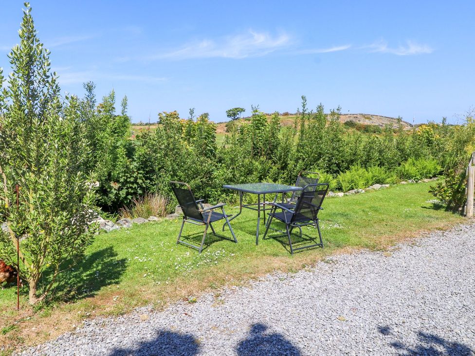 A garden with a table and chairs at The Cabin in Amlwch