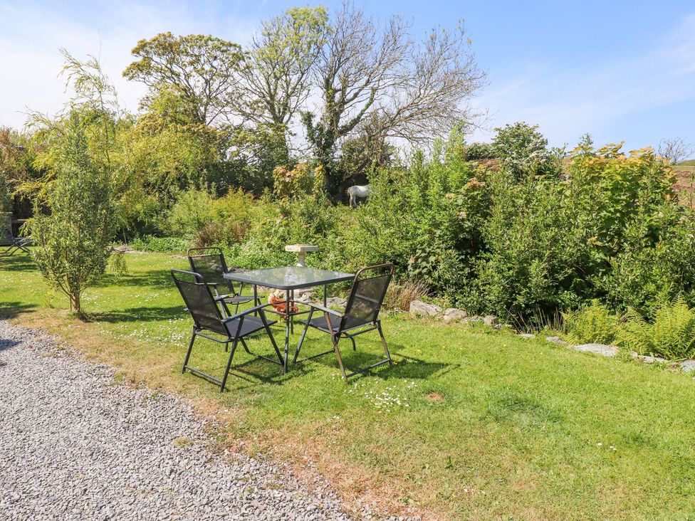 A garden with a table and chairs at The Cabin in Amlwch