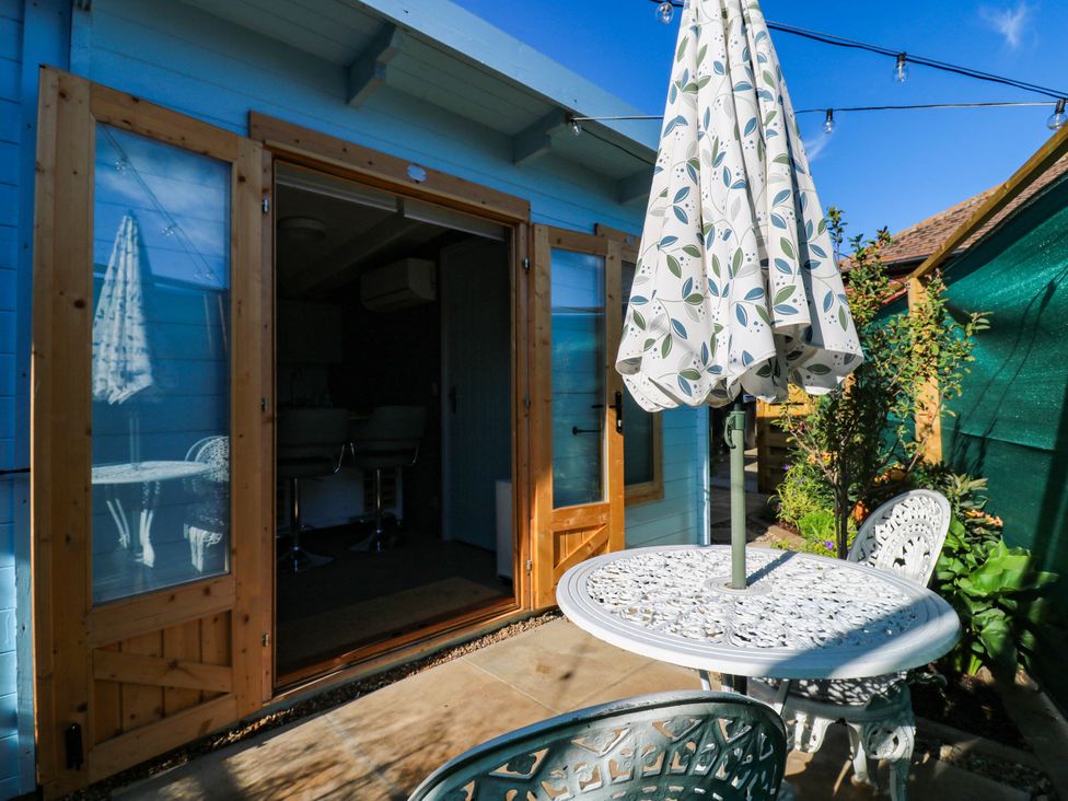 An outdoor seating area with a table and chairs at The Cabin in Herne Bay