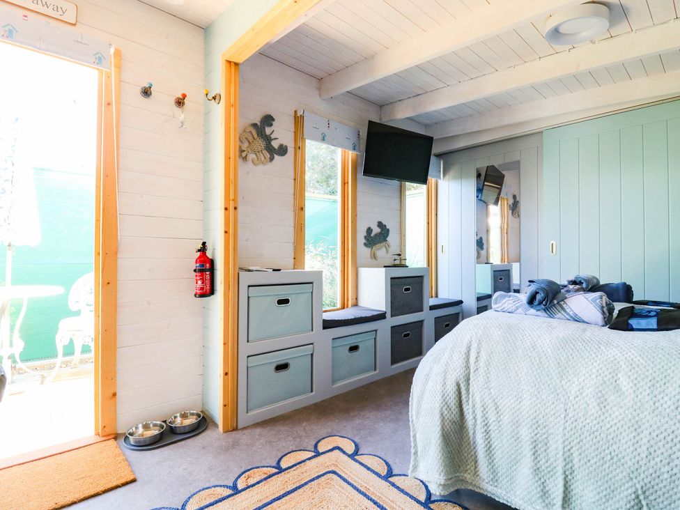A bedroom with a bed and storage unit at The Cabin in Herne Bay