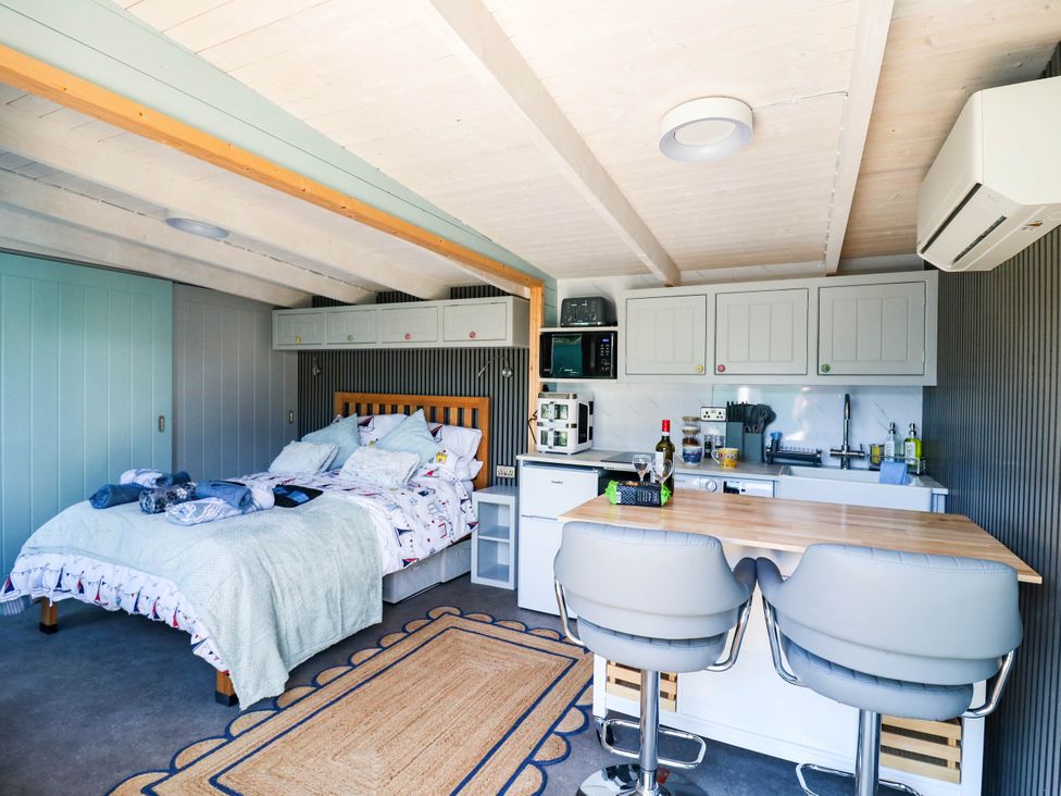 A studio with a bed and kitchen area at The Cabin in Herne Bay