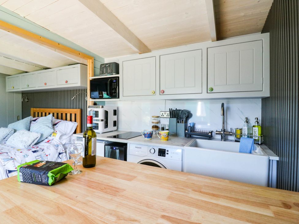 A kitchen with a bed in view at The Cabin in Herne Bay