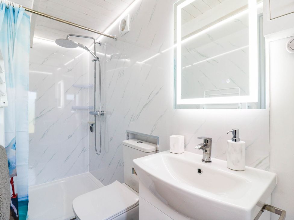 A bathroom with a shower, toilet, and sink at The Cabin in Herne Bay