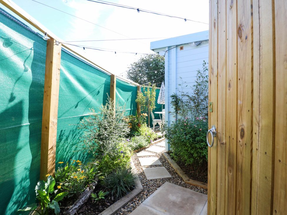 A garden with a pathway and plants at The Cabin in Herne Bay