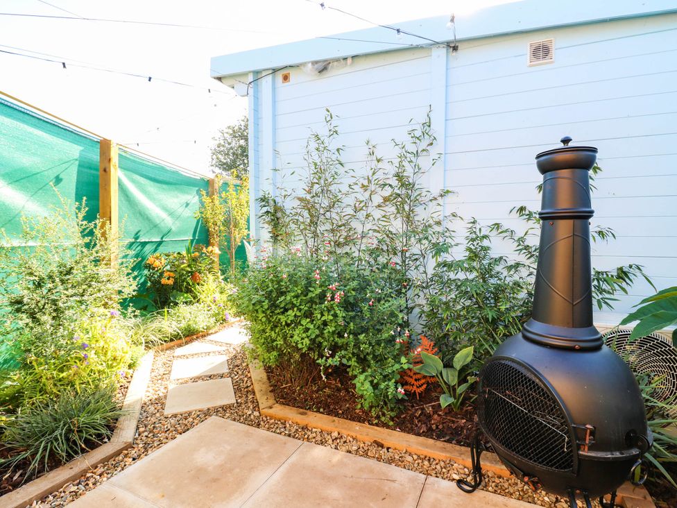 A garden with plants and an outdoor fireplace at The Cabin in Herne Bay