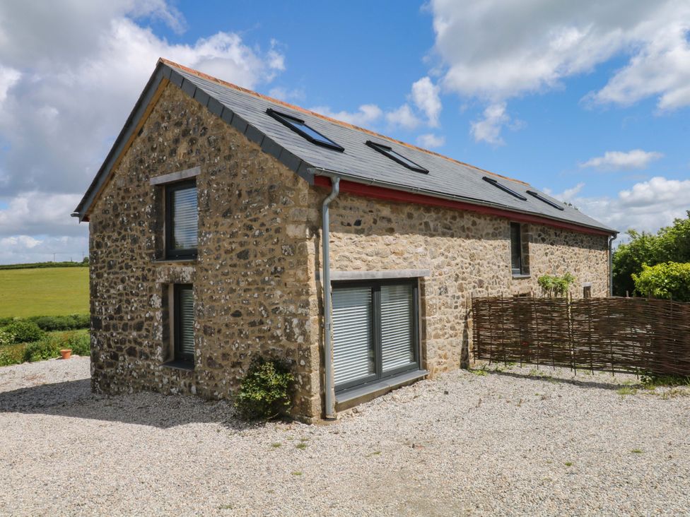 A stone house with windows and a fence at Reddaway Byre Okehampton