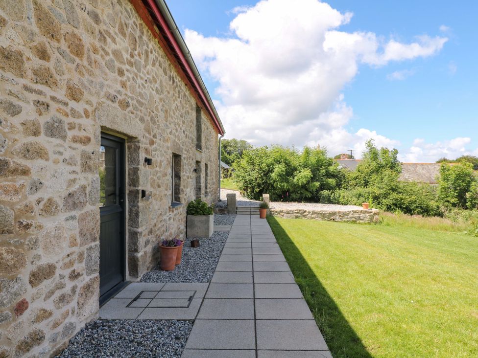 An outdoor area with a stone wall and pathway at Reddaway Byre Okehampton
