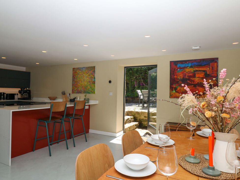 A kitchen with a dining area and doorway leading outside at Reddaway Byre Okehampton