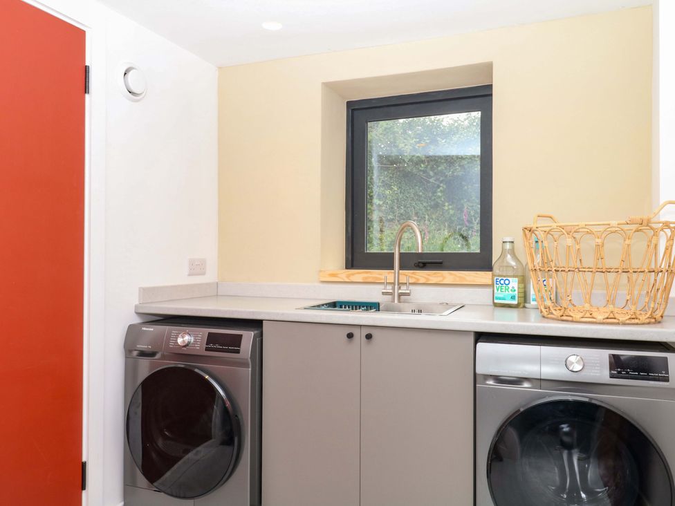 A laundry room with a washing machine and a sink at Reddaway Byre in Okehampton