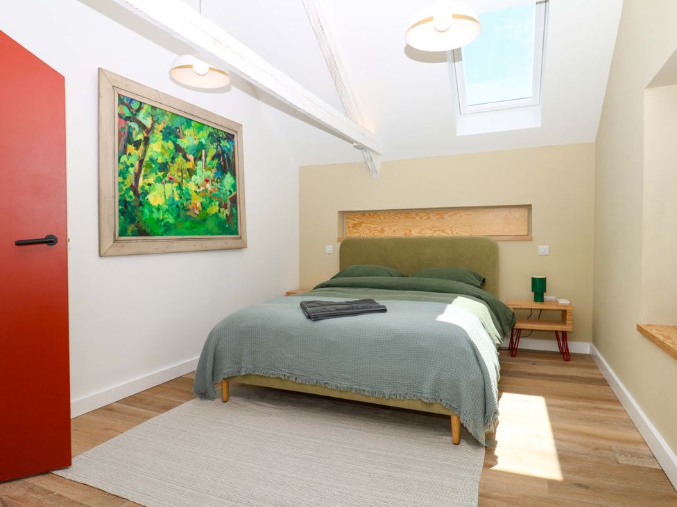 A bedroom with a bed and bedside table at Reddaway Byre Okehampton