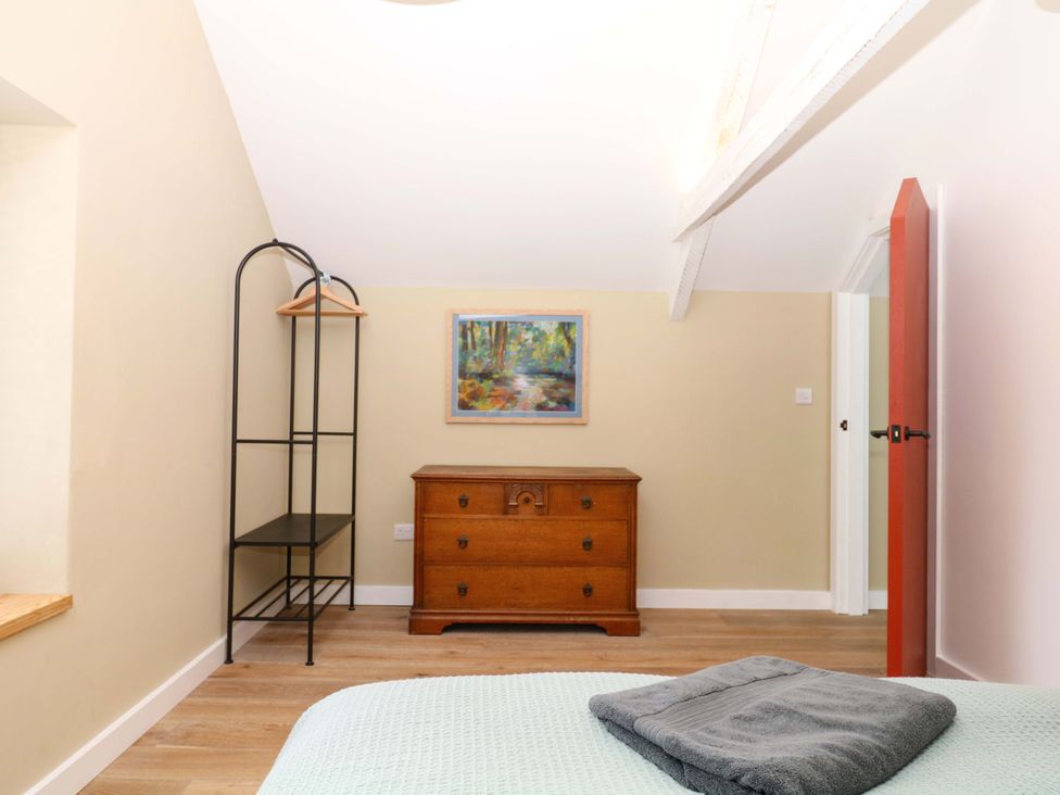 A bedroom with a chest of drawers and a painting at Reddaway Byre Okehampton