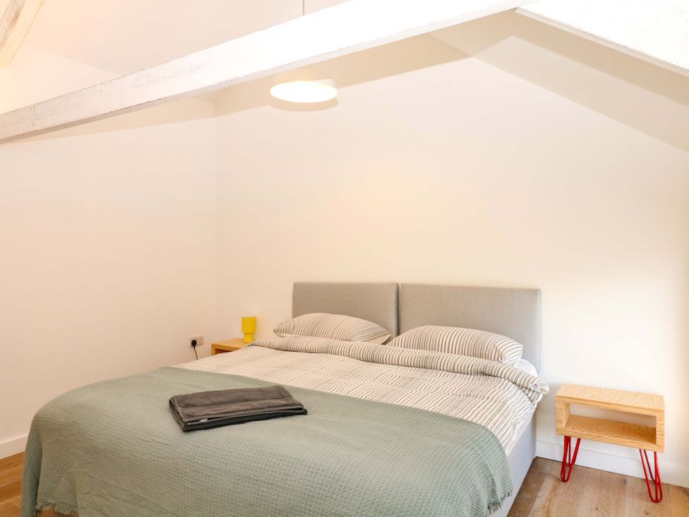 A bedroom with a bed and nightstand at Reddaway Byre in Okehampton