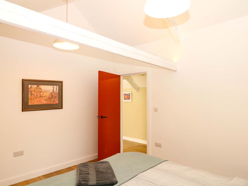 A bedroom with a bed and an open door at Reddaway Byre Okehampton