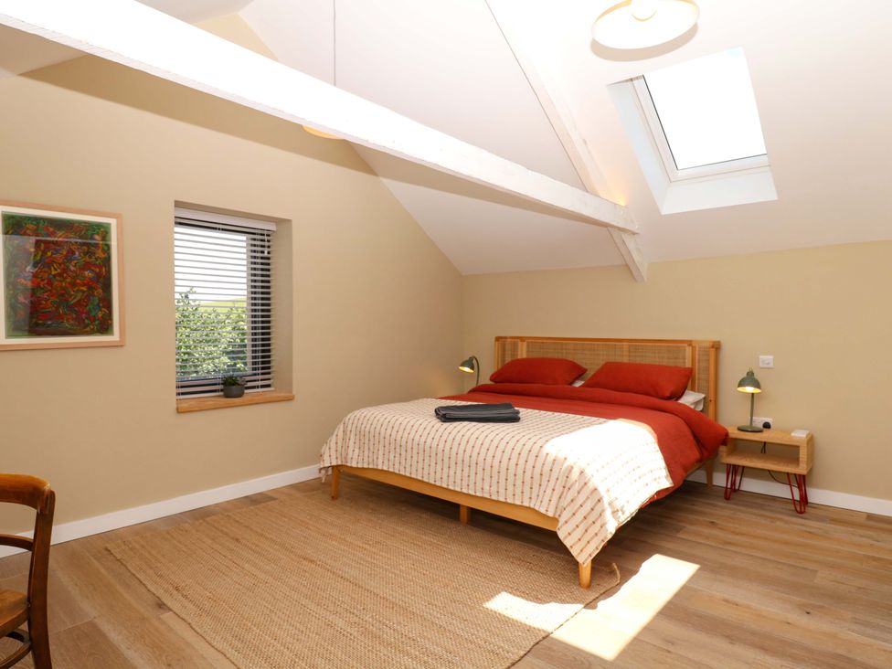 A bedroom with a bed and bedside tables at Reddaway Byre Okehampton