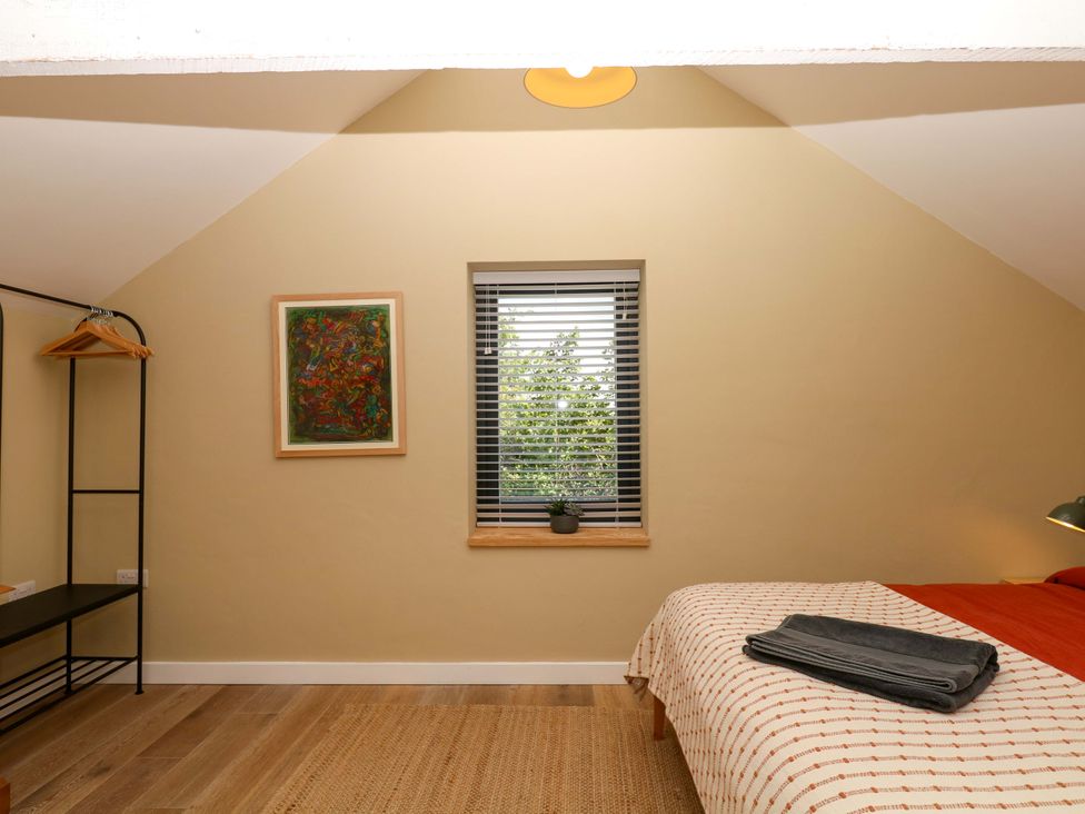 A bedroom with a bed and window at Reddaway Byre Okehampton