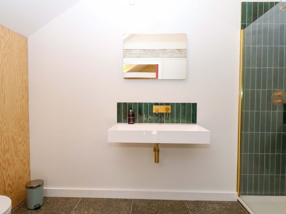 A bathroom with a sink, mirror, shower and toilet at Reddaway Byre Okehampton