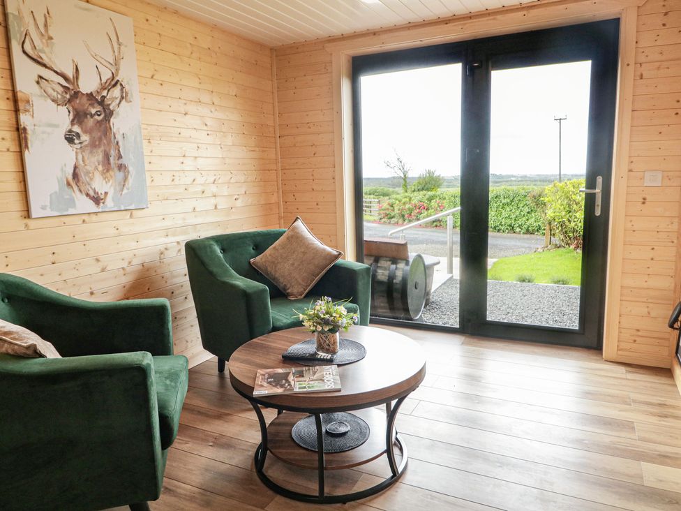 A snug with green sofas and a round table at Alken The Stag in Bushmills, County Antrim
