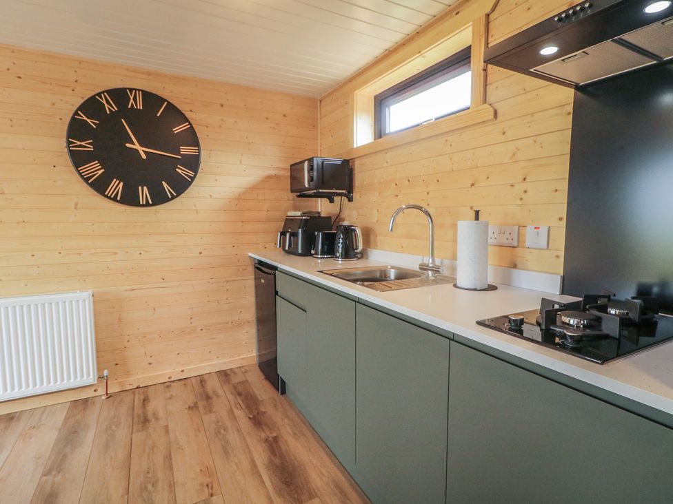A kitchen with a clock, sink and gas stove at Alken The Stag, Bushmills, County Antrim