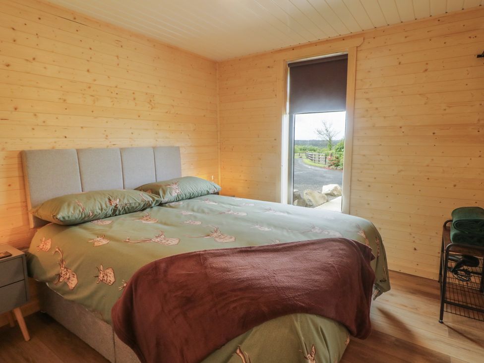 A bedroom with a bed and window at Alken The Stag in Bushmills, County Antrim