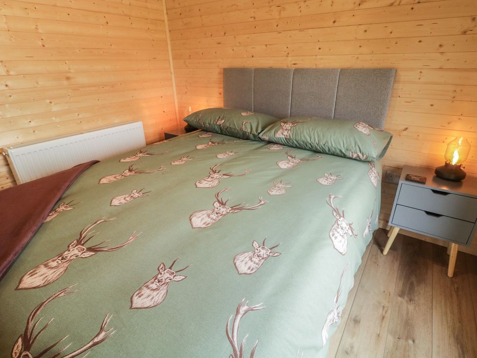 A bedroom with a double bed and a nightstand at Alken The Stag, Bushmills, County Antrim