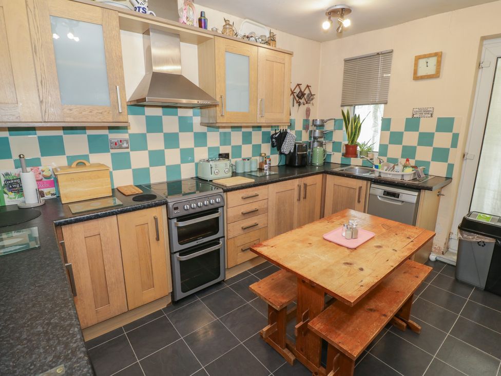 A kitchen with wooden cabinets and a table at Mount Joy in Leicester