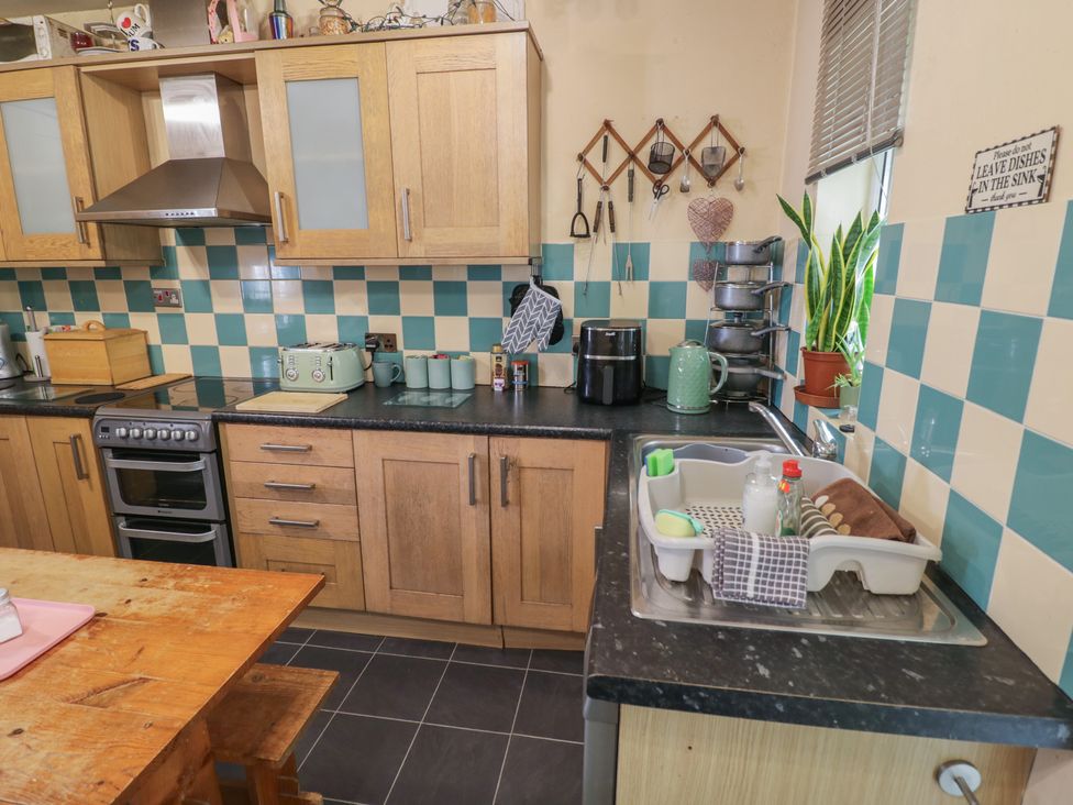 A kitchen with wooden cabinets and appliances at Mount Joy in Leicester