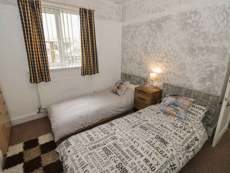 A bedroom with two beds and a bedside table at Mount Joy in Leicester
