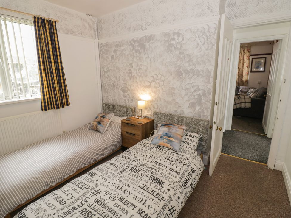 A bedroom with two single beds and a lamp on a nightstand at Mount Joy in Leicester