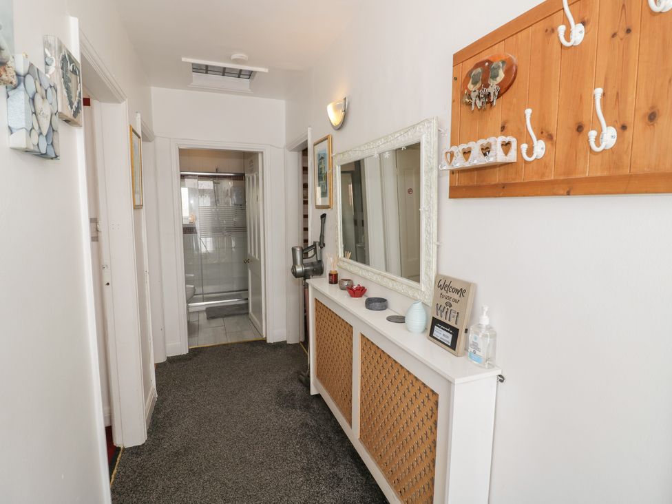 A hallway with a mirror and coat hooks at Mount Joy in Leicester