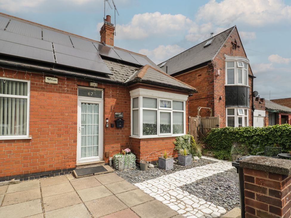 An outdoor view of a house with a pathway and garden at Mount Joy, Leicester