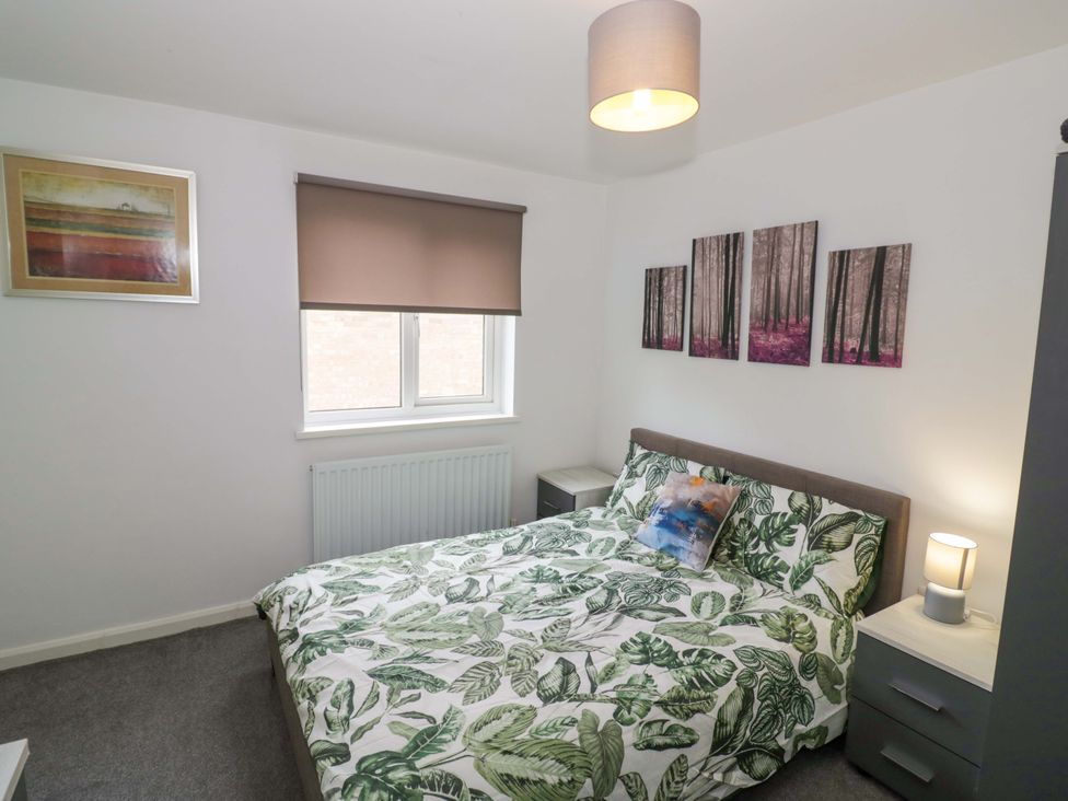 A bedroom with a bed and wall art at 9 Uist Walk in Corby
