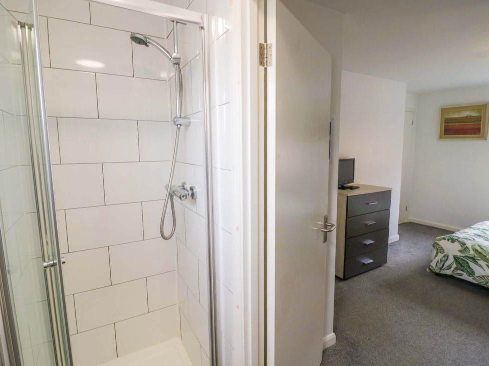 A bathroom with a shower and a bedroom view at 9 Uist Walk in Corby
