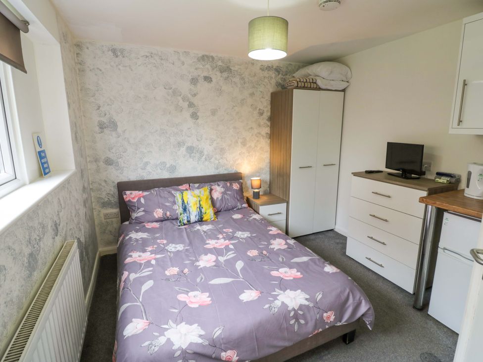 A bedroom with a bed and television at 9 Uist Walk in Corby