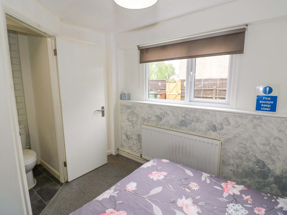 A bedroom with a bed and a window at 9 Uist Walk in Corby