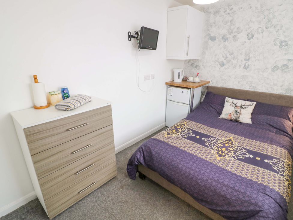 A bedroom with a bed and dresser at 9 Uist Walk in Corby