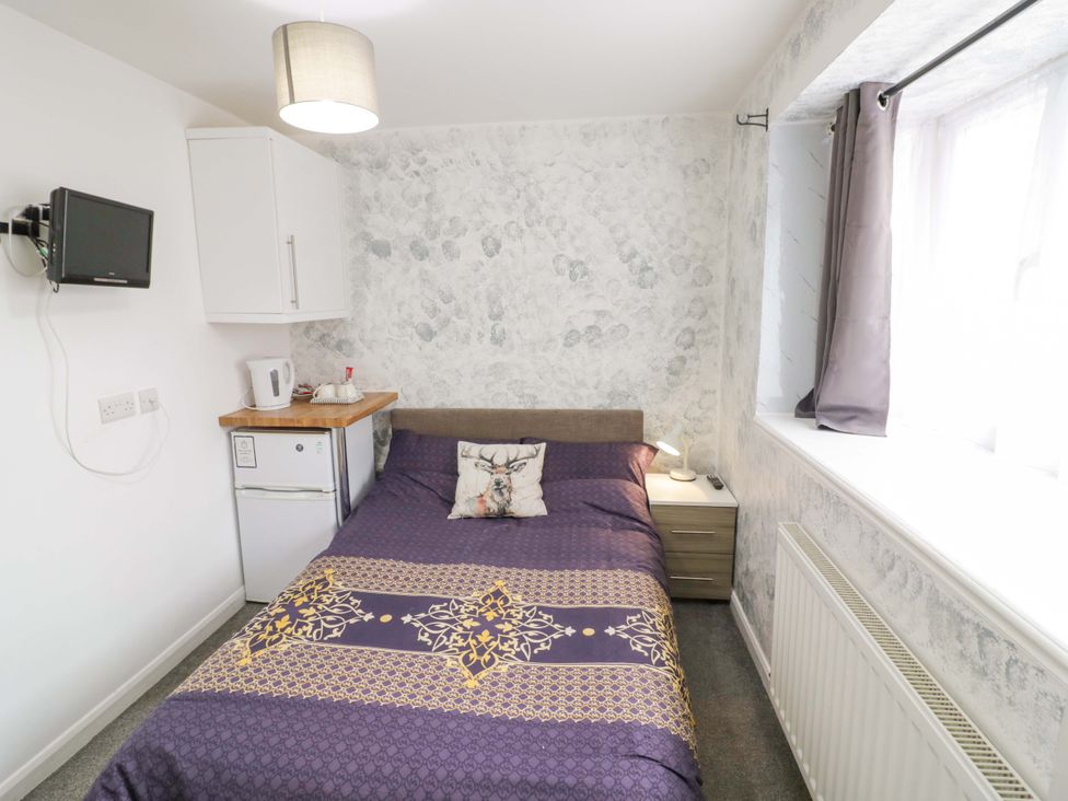 A bedroom with a bed and television at 9 Uist Walk in Corby