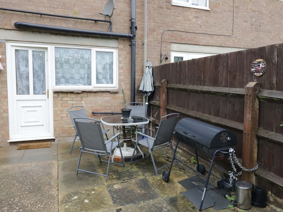 An outdoor seating area with a table and chairs at 9 Uist Walk Corby