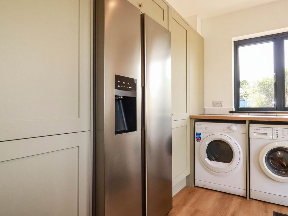 A kitchen with a refrigerator and washing machine at The Granary in Launceston