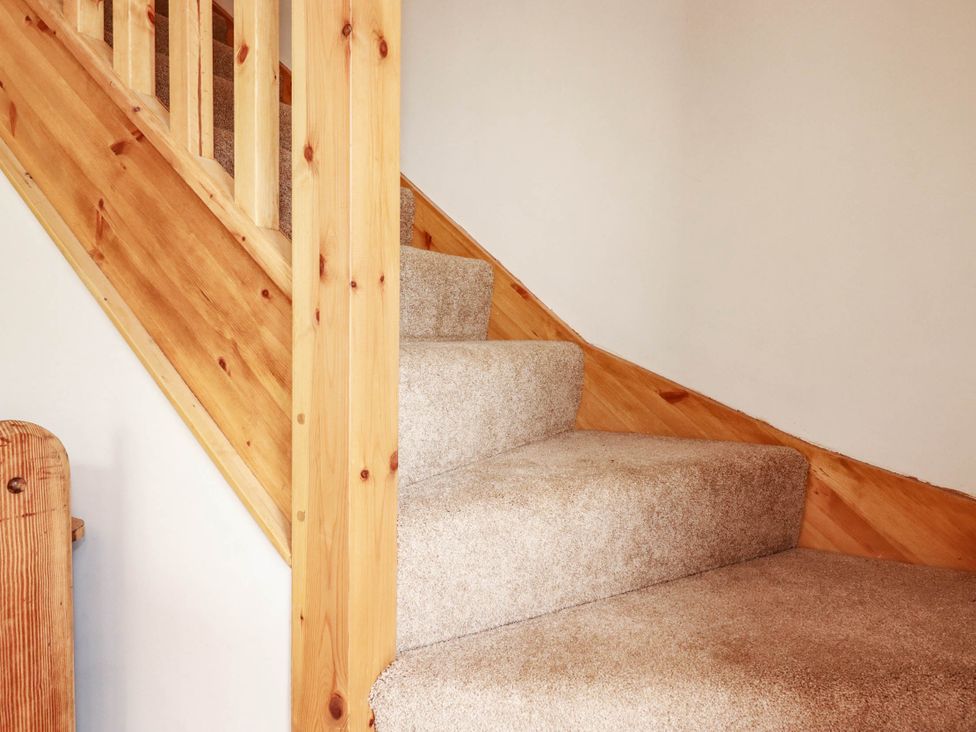A staircase with a wooden railing and carpet at The Granary in Launceston