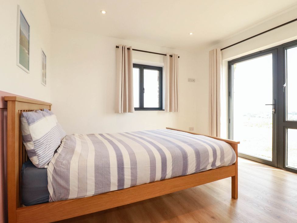 A bedroom with a bed and windows at The Granary in Launceston