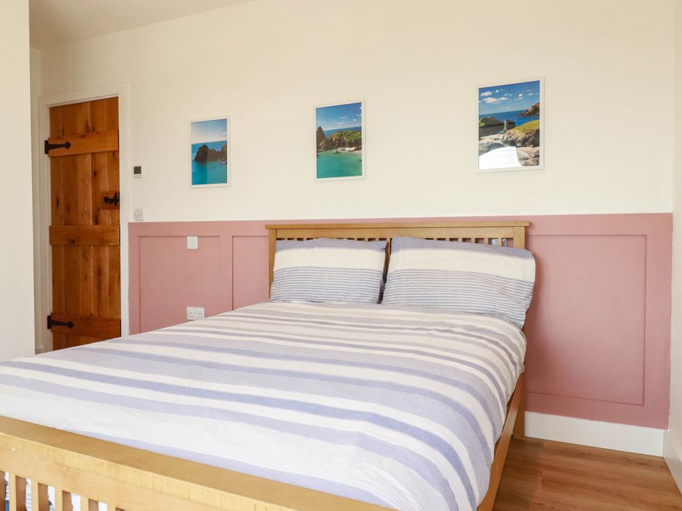 A bedroom with a bed and pictures on the wall at The Granary in Launceston