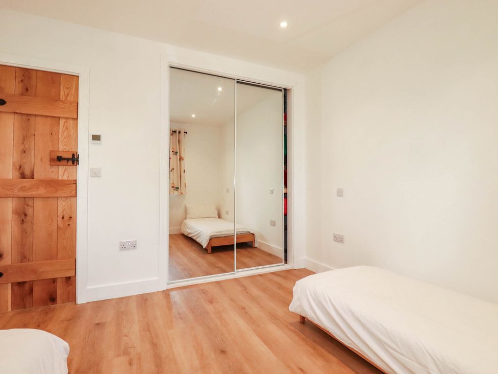 A bedroom with a bed and wardrobe at The Granary in Launceston