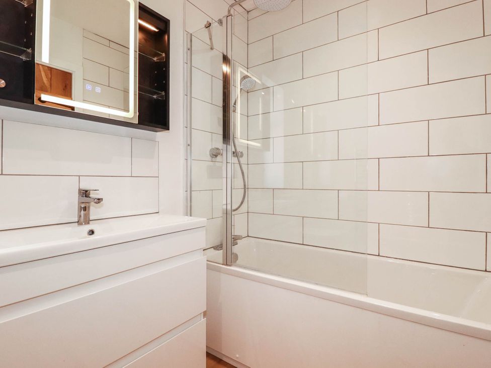 A bathroom with a bathtub and mirror at The Granary in Launceston