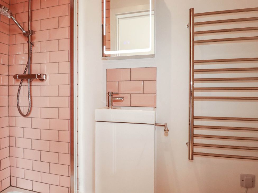 A bathroom with a shower, sink, and mirror at The Granary in Launceston