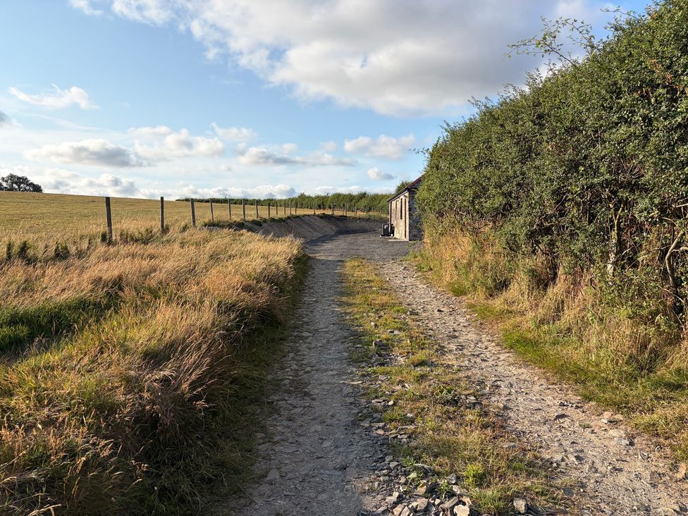 A dirt path leading to a building near a field at High View Barn in Launceston
