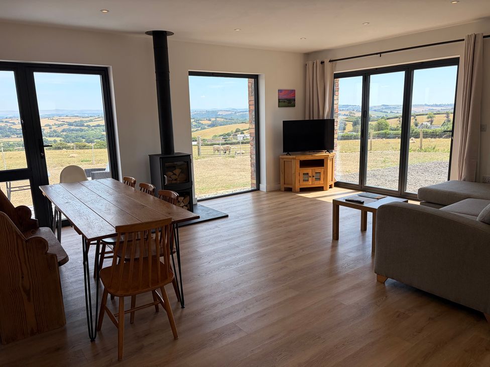 A living room with a table and chairs in High View Barn Launceston