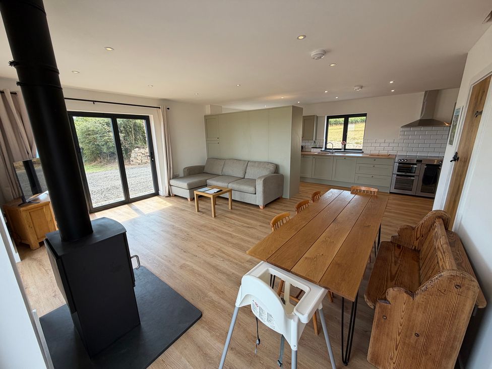 A living room with a sofa and dining table at High View Barn in Launceston
