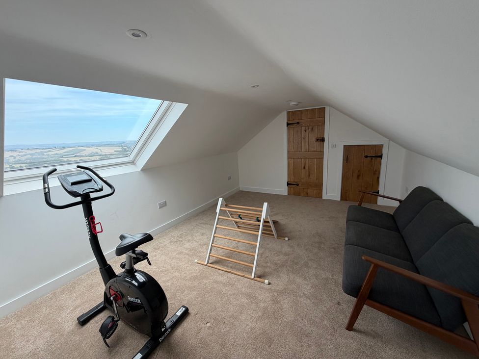 A loft with exercise bike and sofa at High View Barn in Launceston